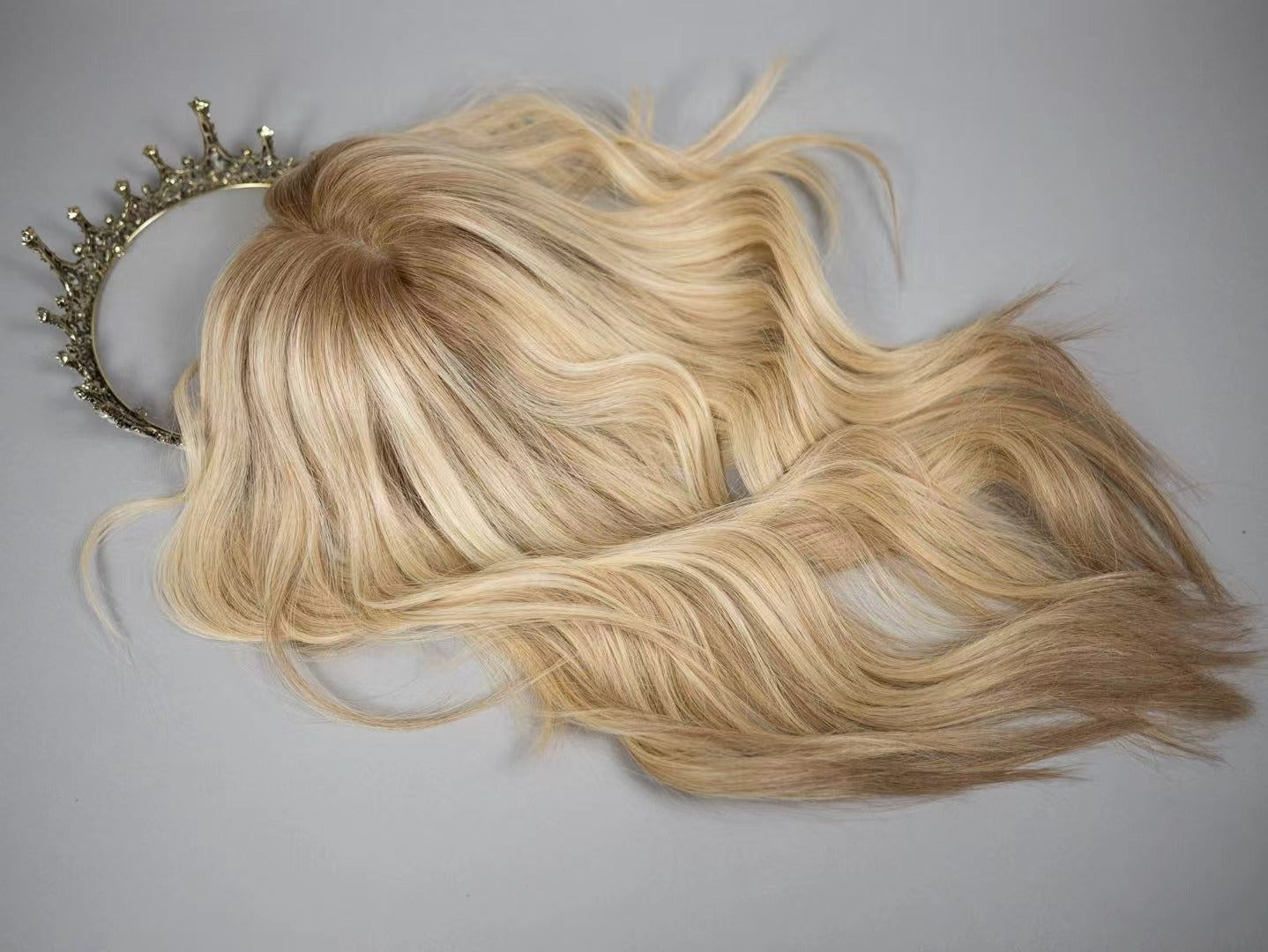 PAIGE rooted blonde topper styled with loose waves